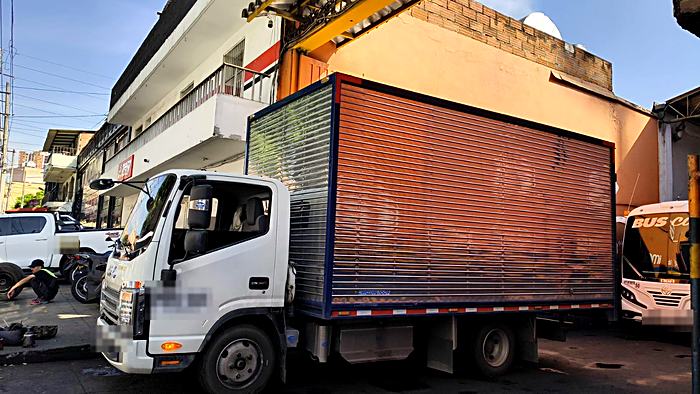 Camión furgón de Inter-Transporte cargando en zona urbana